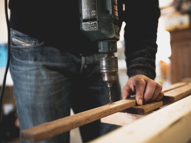 Man Holding Wooden Stick While Drilling Hole